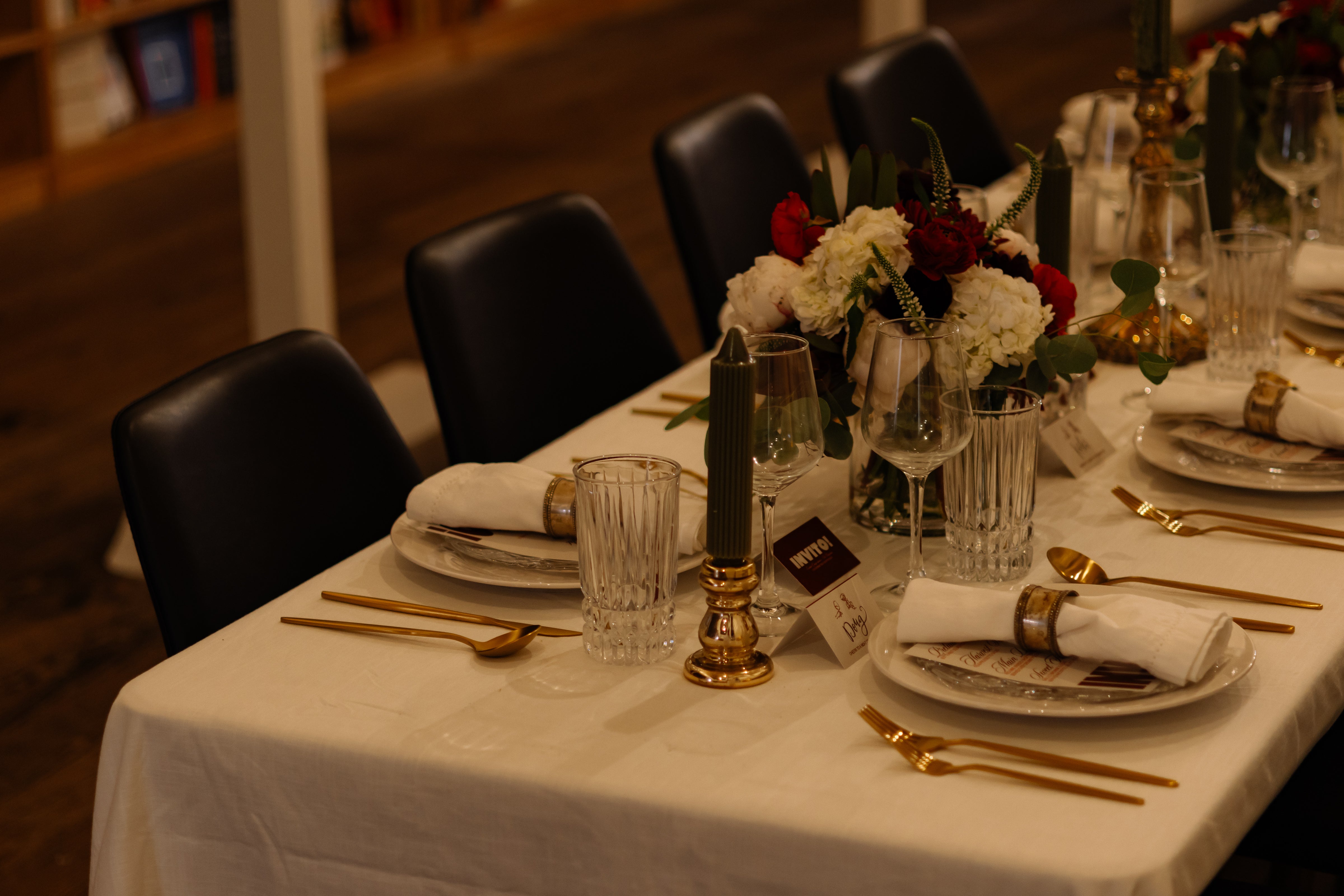 Dining table set and waiting for guests to arrive with a beautiful bouquet of flowers and tall candles.